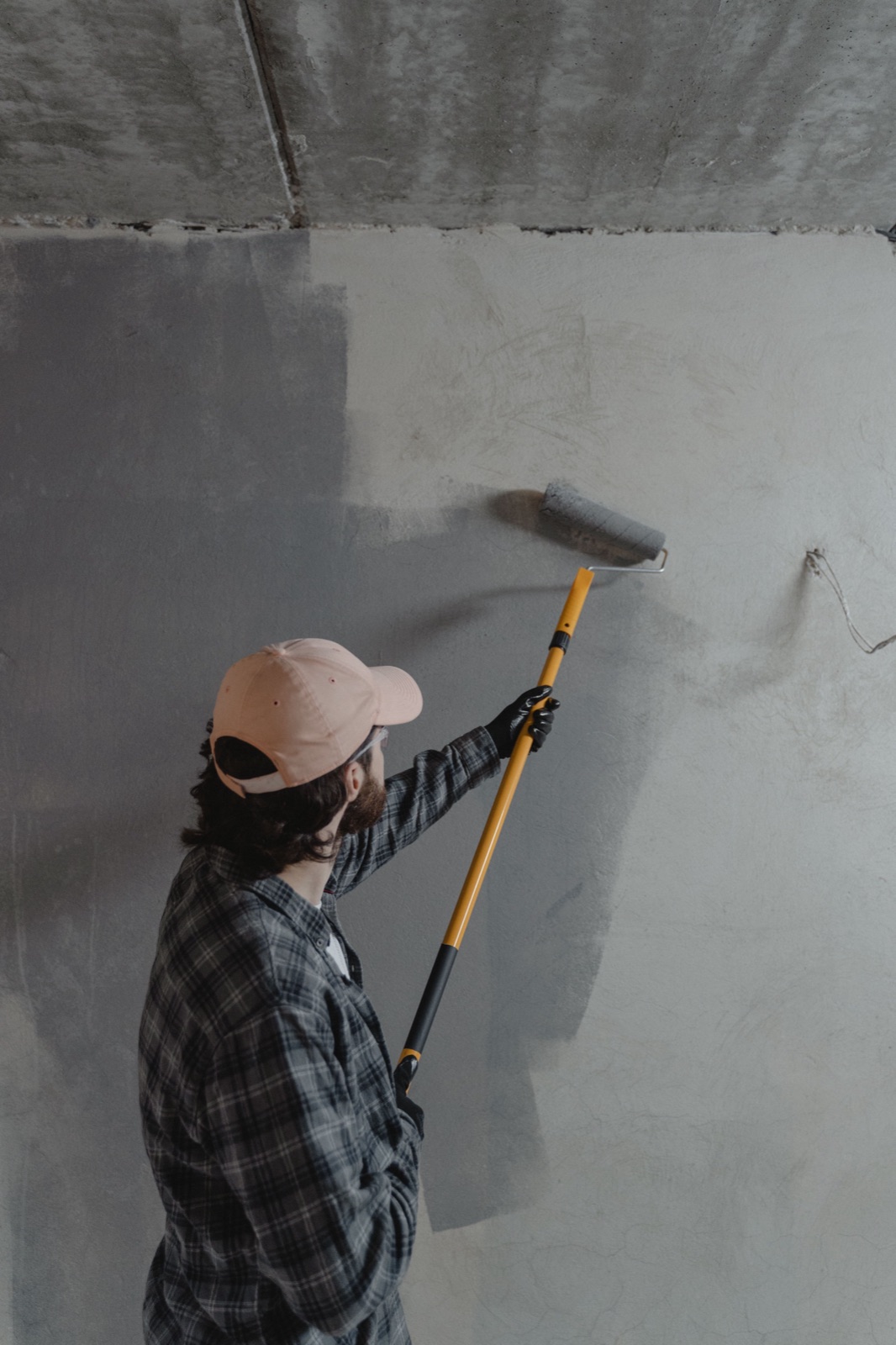 Rolling primer onto a bare, patched wall